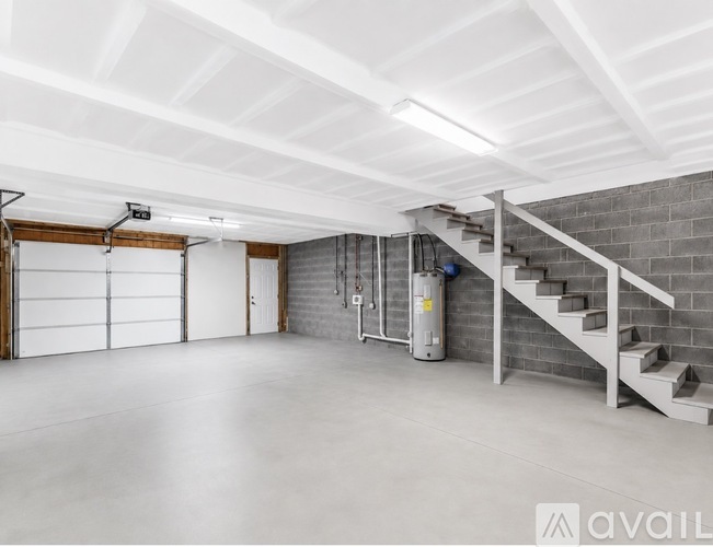 A spacious garage with a staircase leading to an upper level.
