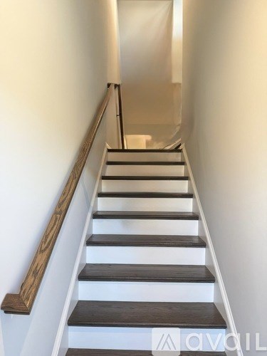 A staircase with wooden steps and a metal railing.