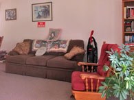A living room with a brown couch and a red chair.