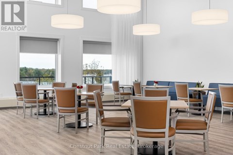 A room with a table and chairs and a window overlooking a body of water.