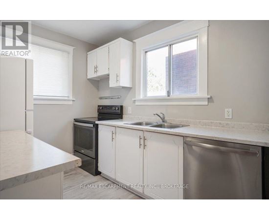 A kitchen with white cabinets and a stainless steel dishwasher.