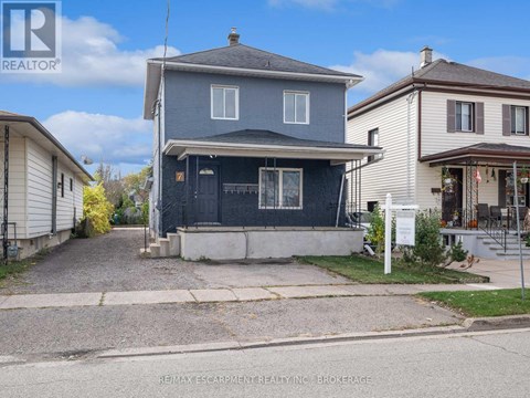 A blue house with a white fence in front of it.