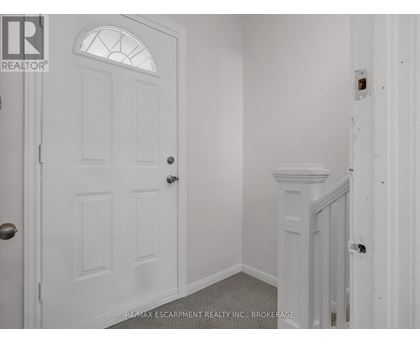 A white door with a glass window is in a room with white walls.
