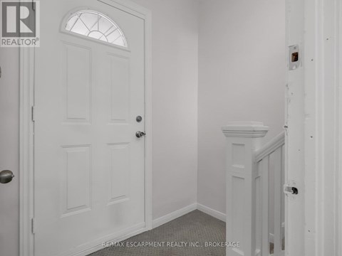 A white door with a glass window is in a room with white walls.