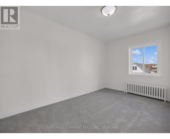 A room with a window and a radiator on the floor.