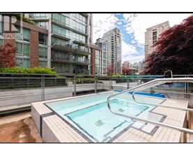 A swimming pool in a residential area with apartment buildings in the background.