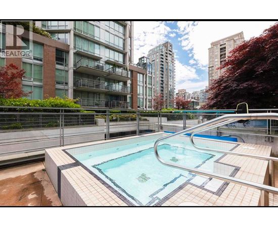 A swimming pool in a residential area with apartment buildings in the background.