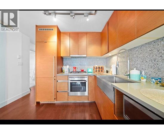 A modern kitchen with wooden cabinets and stainless steel appliances.
