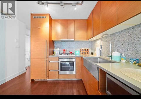 A modern kitchen with wooden cabinets and stainless steel appliances.