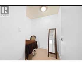 A bedroom with a bed, chair and mirror.