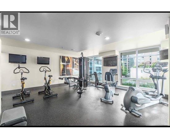 A gym with a variety of exercise equipment including treadmills, stationary bikes, and weight machines.