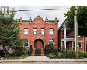 A red brick building with a black and white striped staircase.