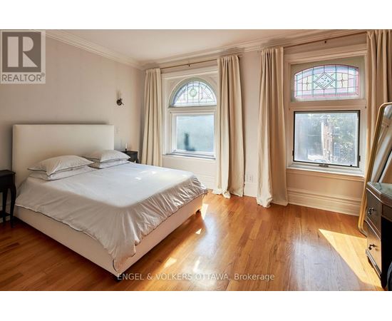A bedroom with a large bed and a window with a view of trees.
