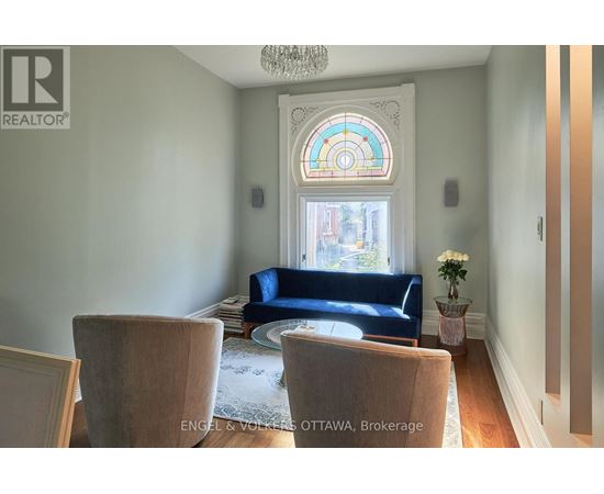A living room with a blue couch and a chandelier.