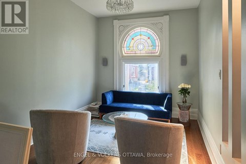 A living room with a blue couch and a chandelier.