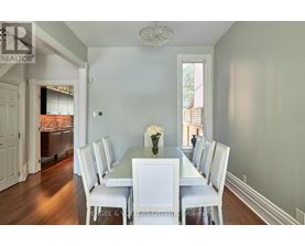 A dining room with a white table and chairs.