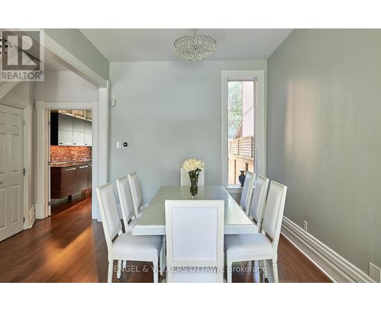 A dining room with a white table and chairs.