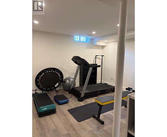 A gym room with a treadmill, exercise balls and benches.