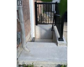 A black metal railing on a concrete staircase.