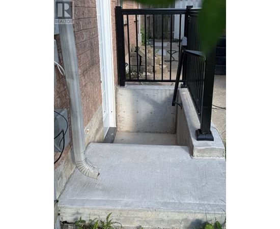A black metal railing on a concrete staircase.