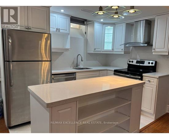 A kitchen with a refrigerator, sink, and stove.