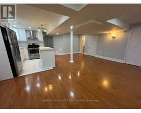 A spacious kitchen with wooden floors and white cabinets.