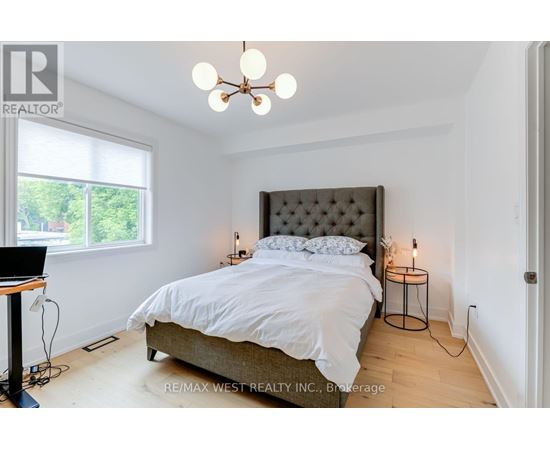 A bedroom with a large bed and a chandelier.