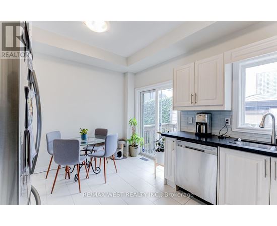 A kitchen with a table and chairs in front of a window.