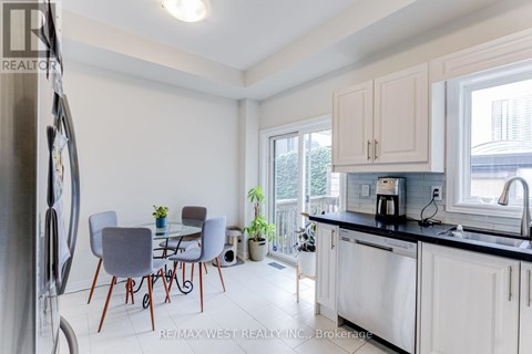A kitchen with a table and chairs in front of a window.
