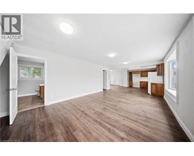 A spacious room with wooden flooring and white walls.