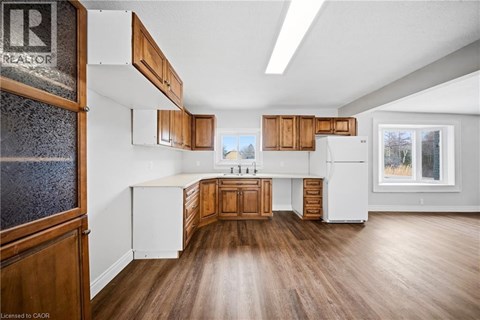 A kitchen with wooden cabinets and a white refrigerator.