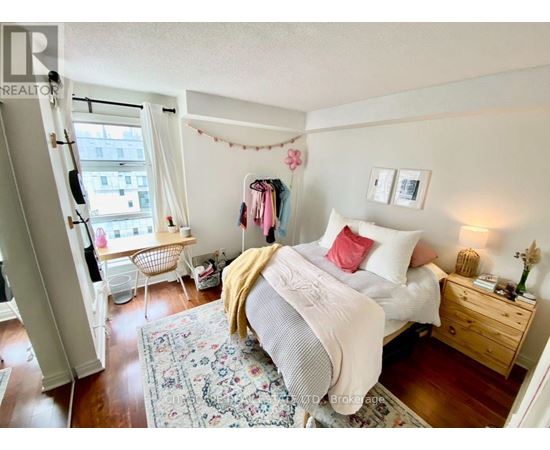 A bedroom with a bed, nightstand, and chair.