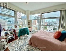 A bedroom with a large bed and a view of the city.