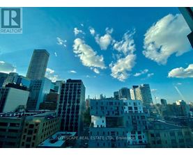 A cityscape with buildings of various heights and architectural styles under a blue sky with scattered clouds.