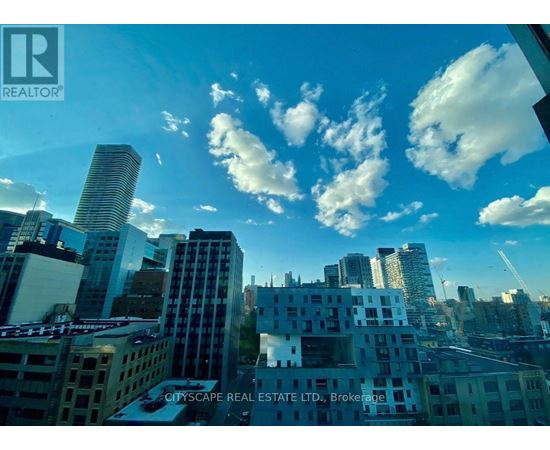 A cityscape with buildings of various heights and architectural styles under a blue sky with scattered clouds.