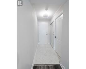 A hallway with marble flooring and white walls.
