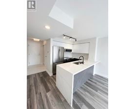 A modern kitchen with a white island and stainless steel appliances.