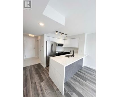 A modern kitchen with a white island and stainless steel appliances.