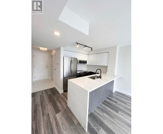 A modern kitchen with a white island and stainless steel appliances.