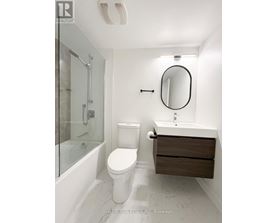 A white toilet sits next to a sink in a bathroom.