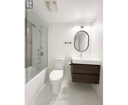 A white toilet sits next to a sink in a bathroom.