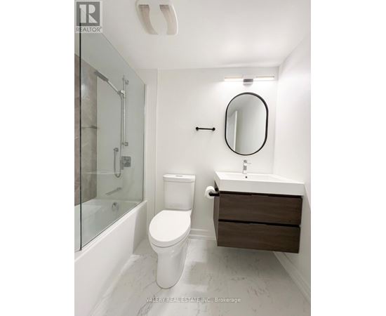 A white toilet sits next to a sink in a bathroom.