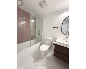 A bathroom with a toilet, sink, and shower.
