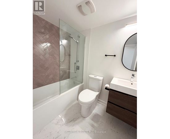 A bathroom with a toilet, sink, and shower.