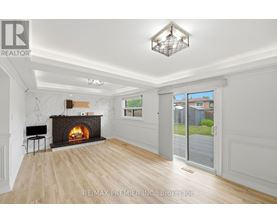 A spacious living room with a fireplace and a view of the backyard.