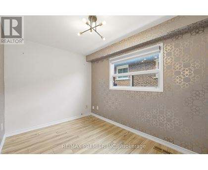 A room with a window showing a brick building outside.