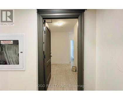 A hallway with a brokerage sign on the wall.