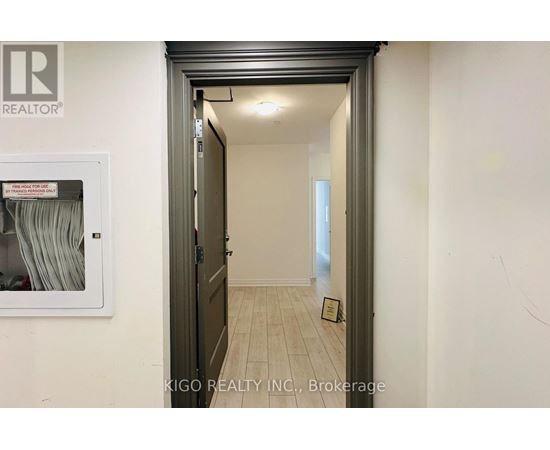 A hallway with a brokerage sign on the wall.