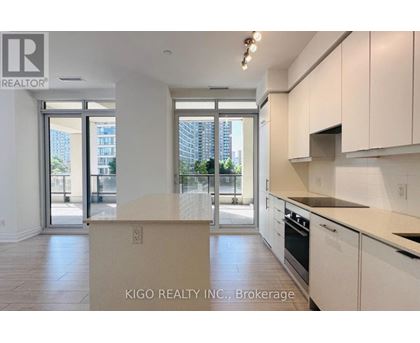 A kitchen with white cabinets and a countertop with a sign that says KIGO REALTY INC., Brokerage.