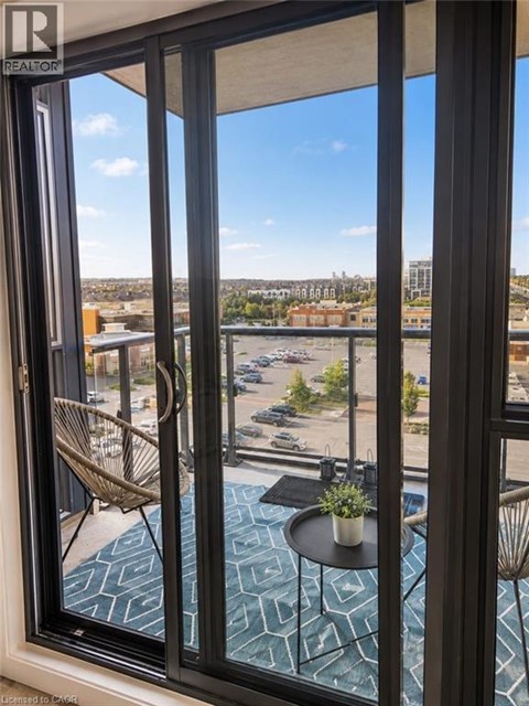 A balcony with a table and chairs overlooking a parking lot.